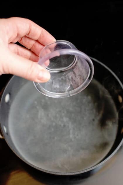 Adding vinegar into boiling pot of water