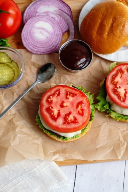 Tomato on top of burger next to other toppings
