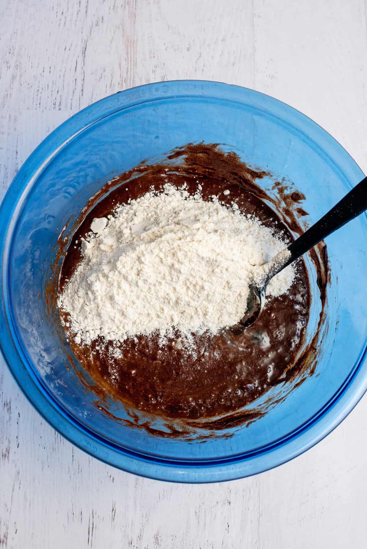 Adding flour to the brownie mixture