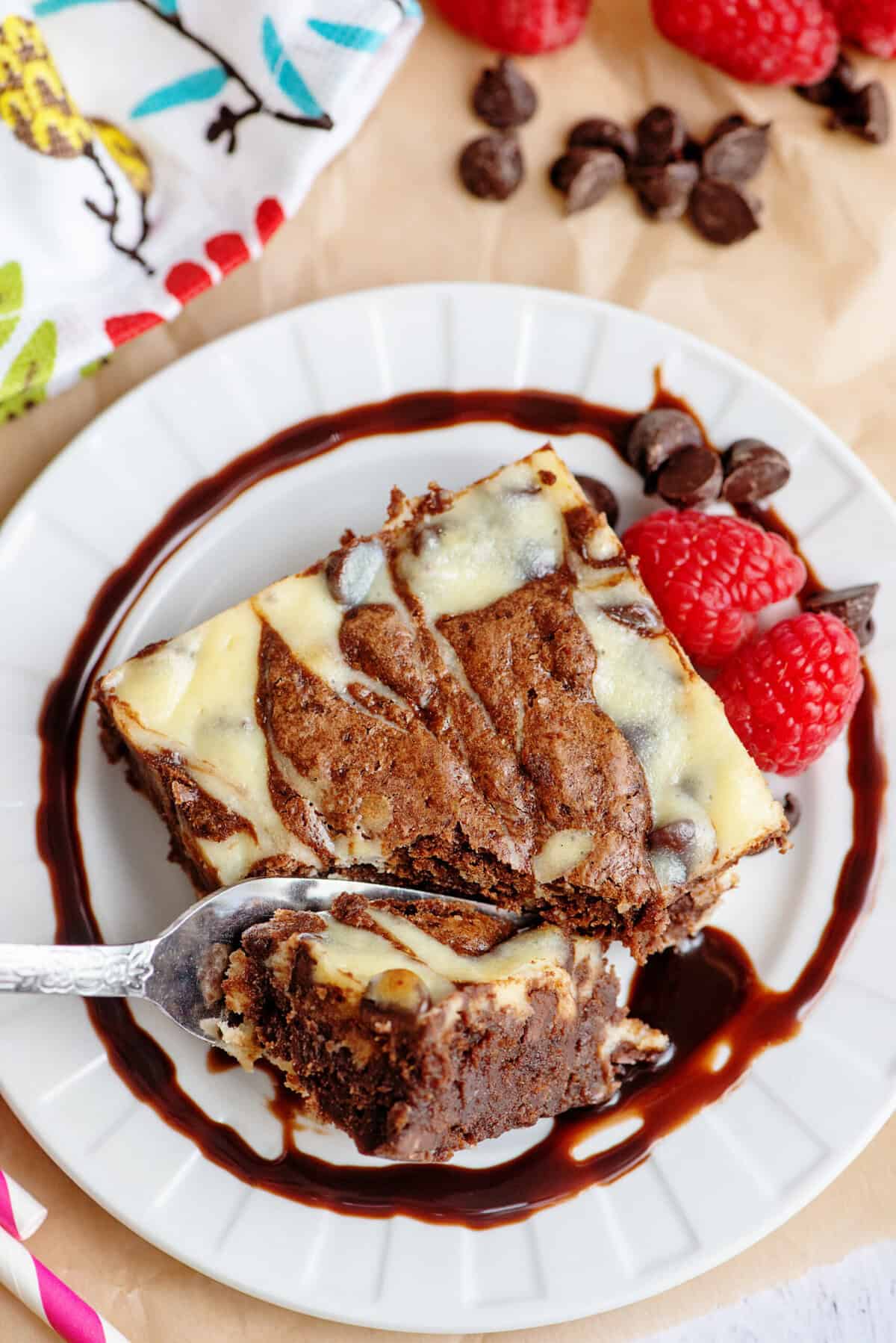 Eating a plated marble cheesecake brownie with a fork