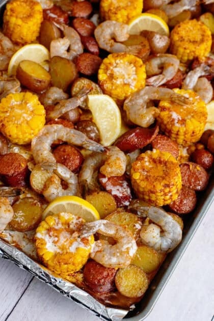 Raw shrimp put onto cooked potatoes, corn, and sausage