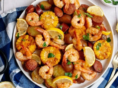 Sheet pan low country seafood boil plated serving next to ingredients