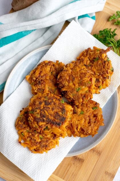 Sweet potato fritters being cooled on a paper towel