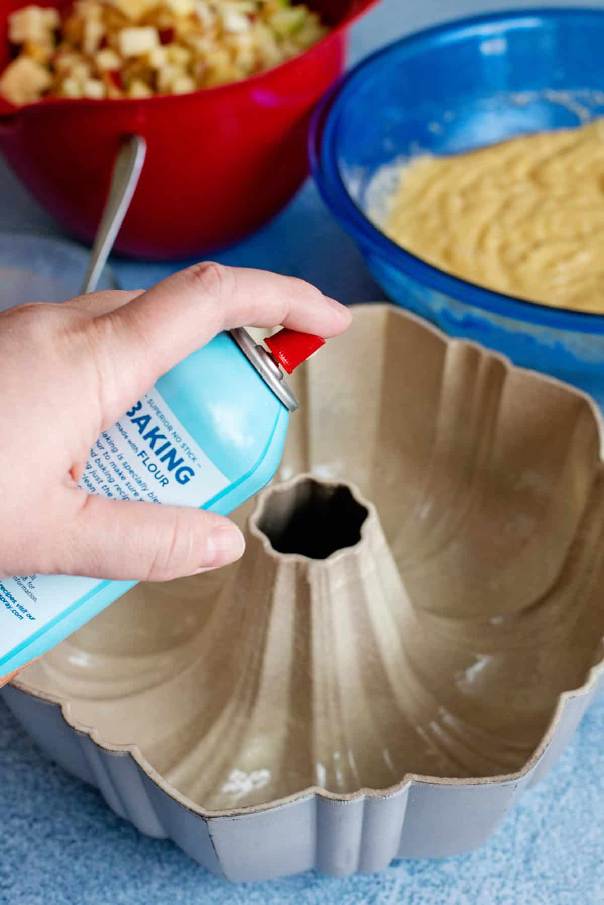 Spraying a bundt pan with non-stick spray.
