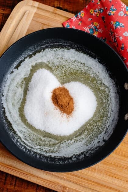 Mixing sugar, cinnamon into a skillet