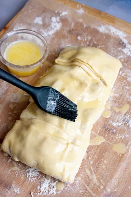 Basting the top of apple strudel with butter