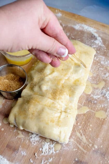 Sprinkling sugar on apple strudel