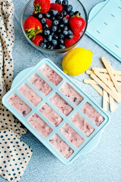 berries and cream mixture poured into the popsicle molds
