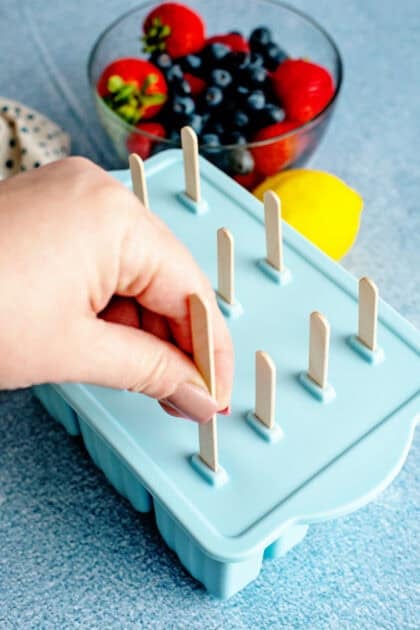 Inserting sticks into the popsicle mold