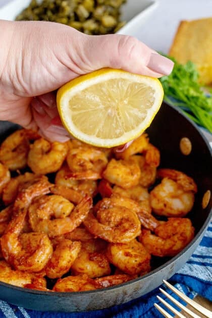 Squeezing lemon into a pan of seared Cajun shrimp