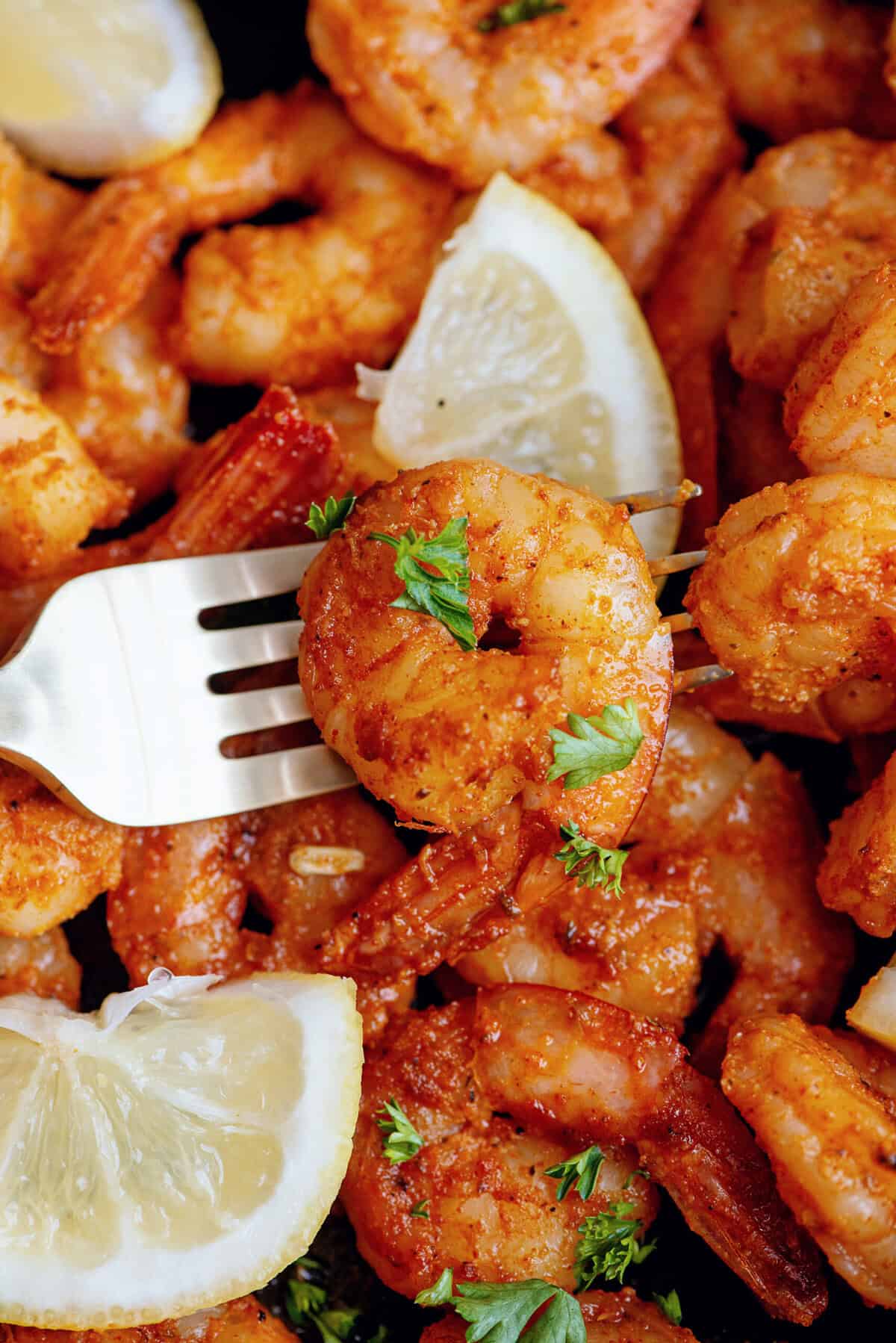 A fork lifting a Cajun shrimp