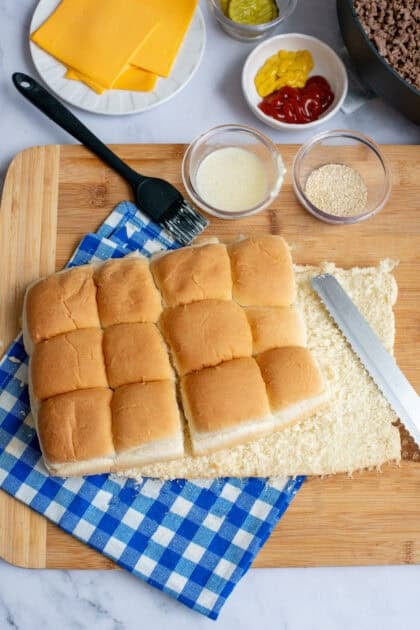 Sheet of rolls being sliced horizontally with a bread knife