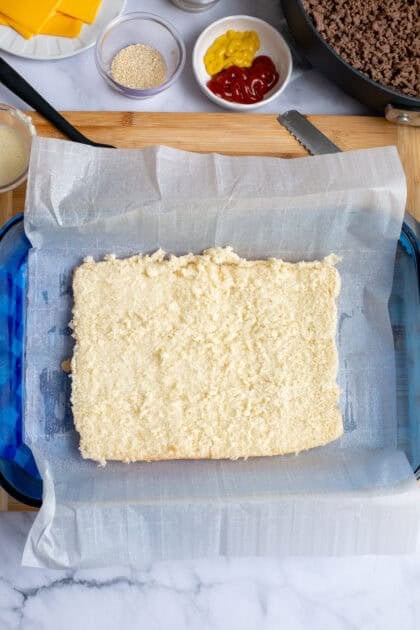 Bottom of the sliced rolls being placed in a baking sheet