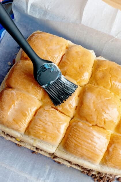 Brushing the tops of the rolls with melted butter