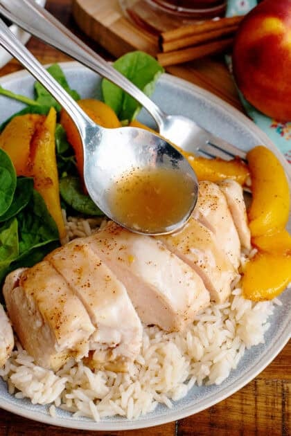 Pouring ginger sauce over a plate of the baked chicken