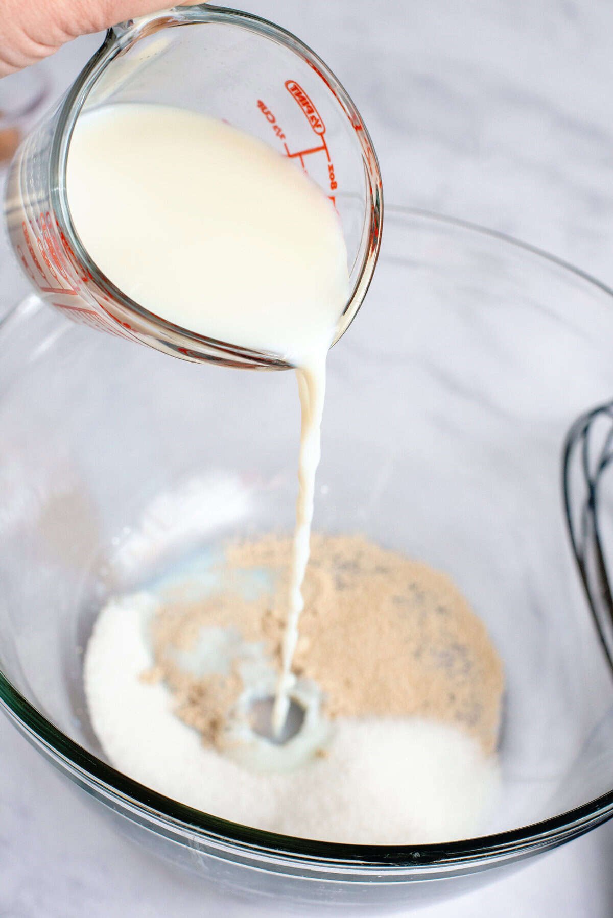 A mixing bowl of warm milk, yeast, and sugar
