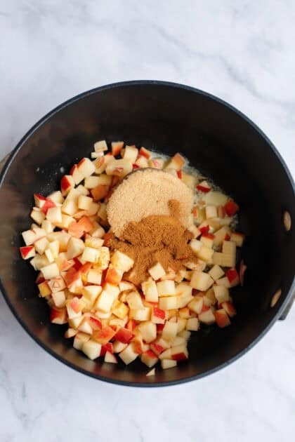 A skillet with apples, brown sugar, cinnamon, and salt