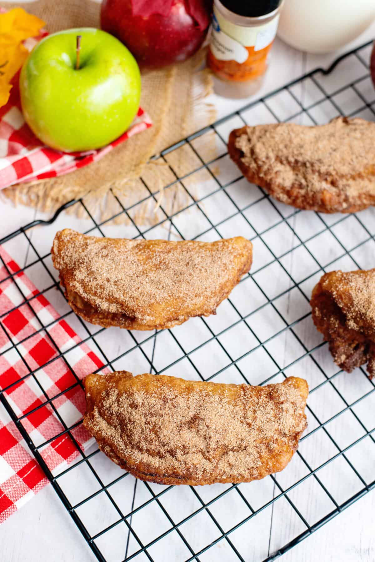 Fried hand apple pies on a cooling rack