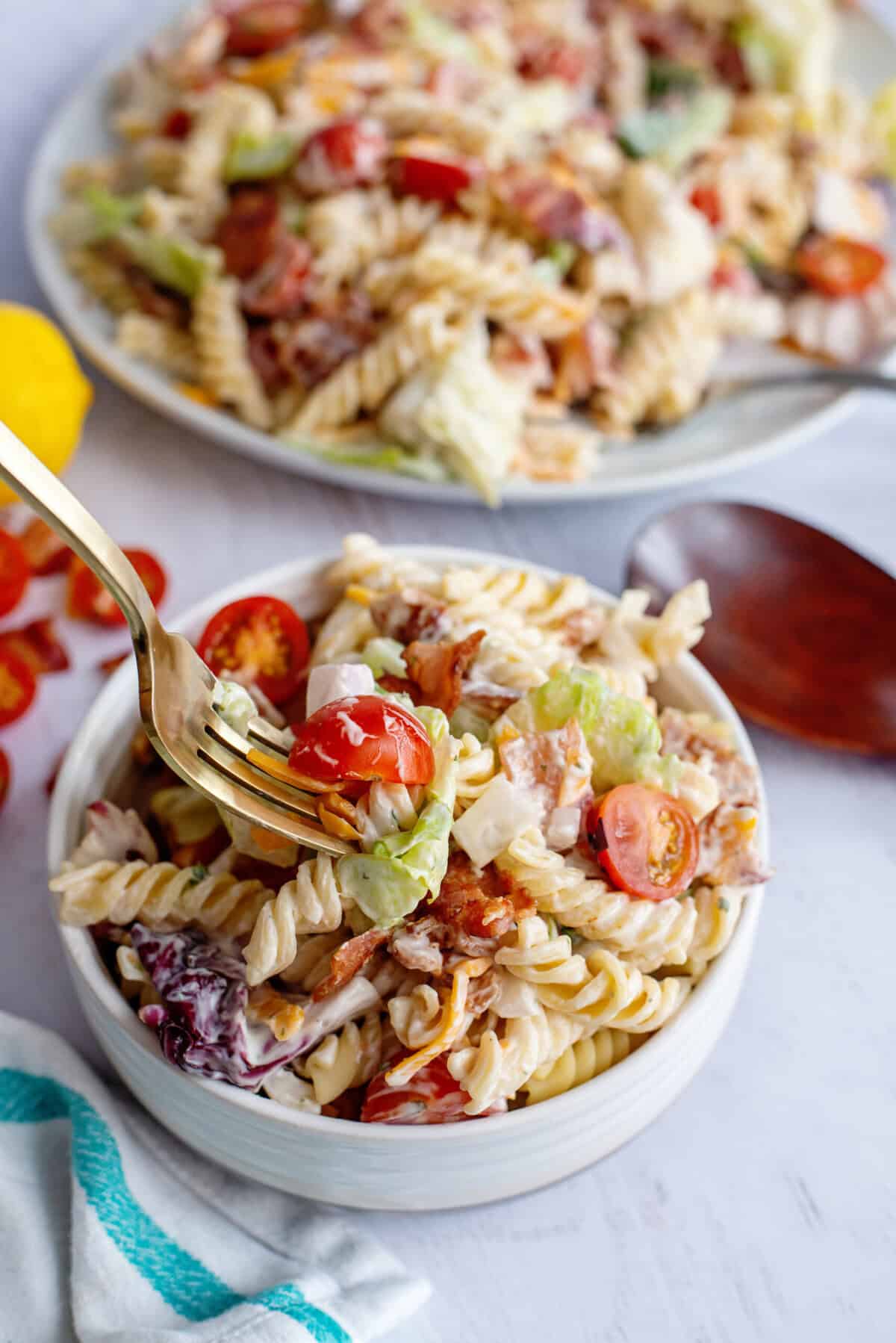 A fork in a bowl of BLT pasta salad