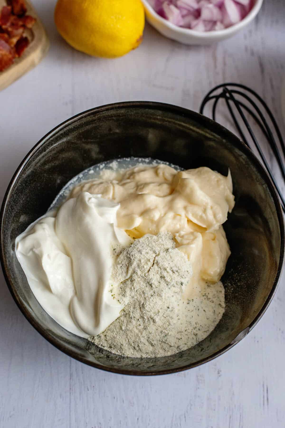 A bowl of mayonnaise, sour cream, ranch seasoning, and lemon juice for the dressing