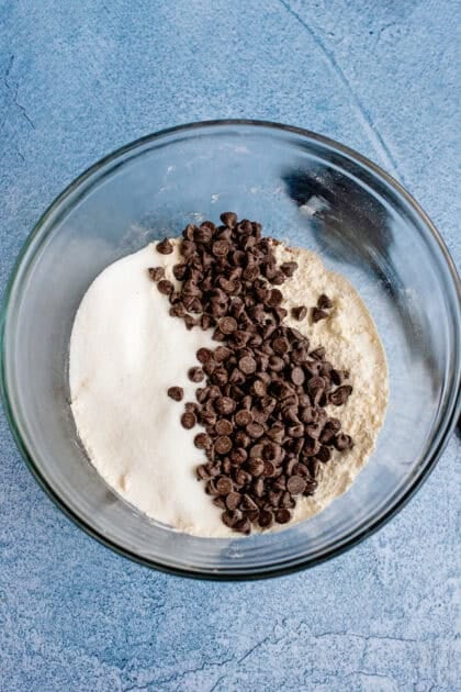 Bowl of chocolate chip biscuit mix with chocolate chips and sugar added