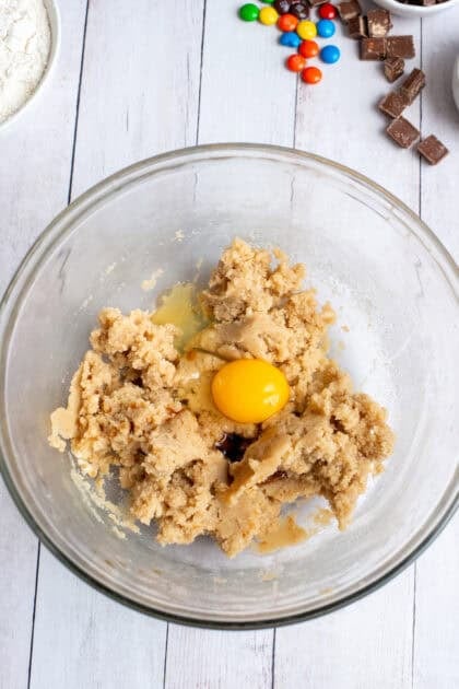 A bowl of Halloween Candy Cookies with an egg