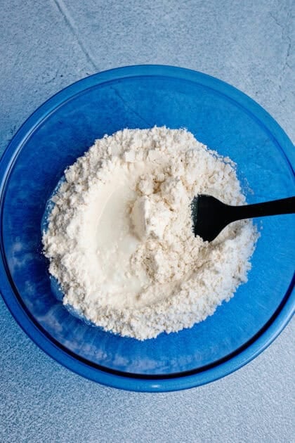 A mixing bowl with easy homemade biscuit mix and milk