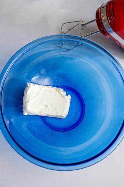 A medium bowl with a stick of cream cheese
