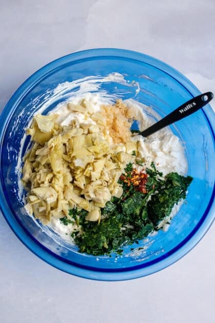 A bowl of spinach artichoke base with veggies