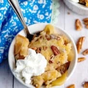 A bowl of apple pecan cobbler with whipped cream