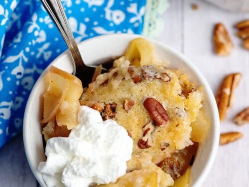 A bowl of apple pecan cobbler with whipped cream