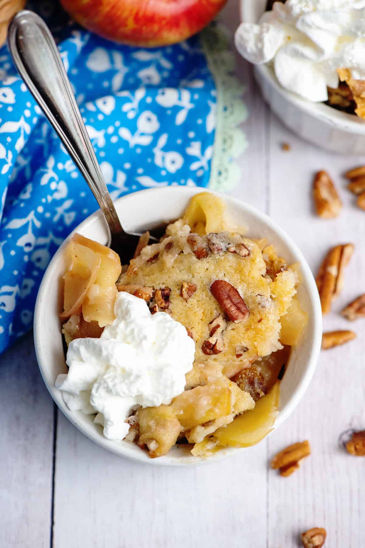 A bowl of apple pecan cobbler with whipped cream