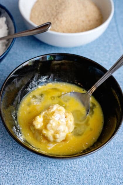 Rolling a mac and cheese ball in egg wash