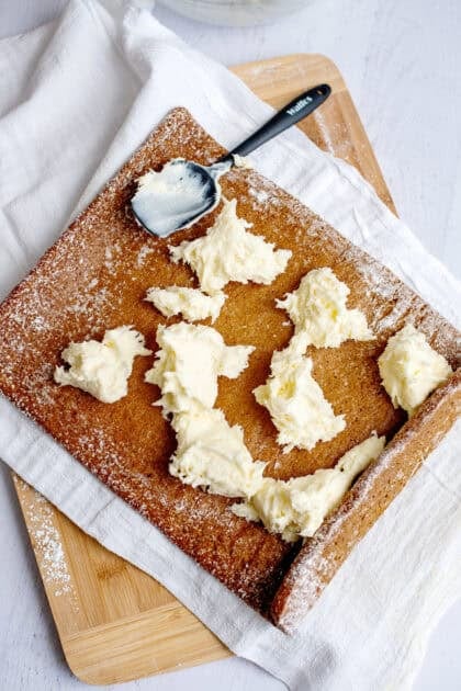 Placing cream cheese filling inside the pumpkin roll