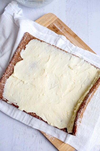 Cream cheese filling evenly spread across the pumpkin roll