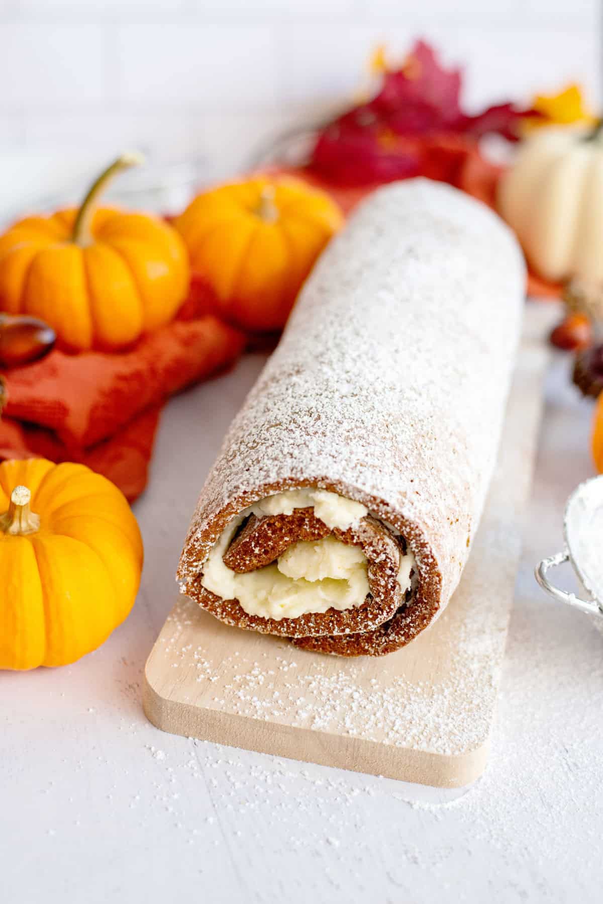 Finished and dusted pumpkin roll on a serving board
