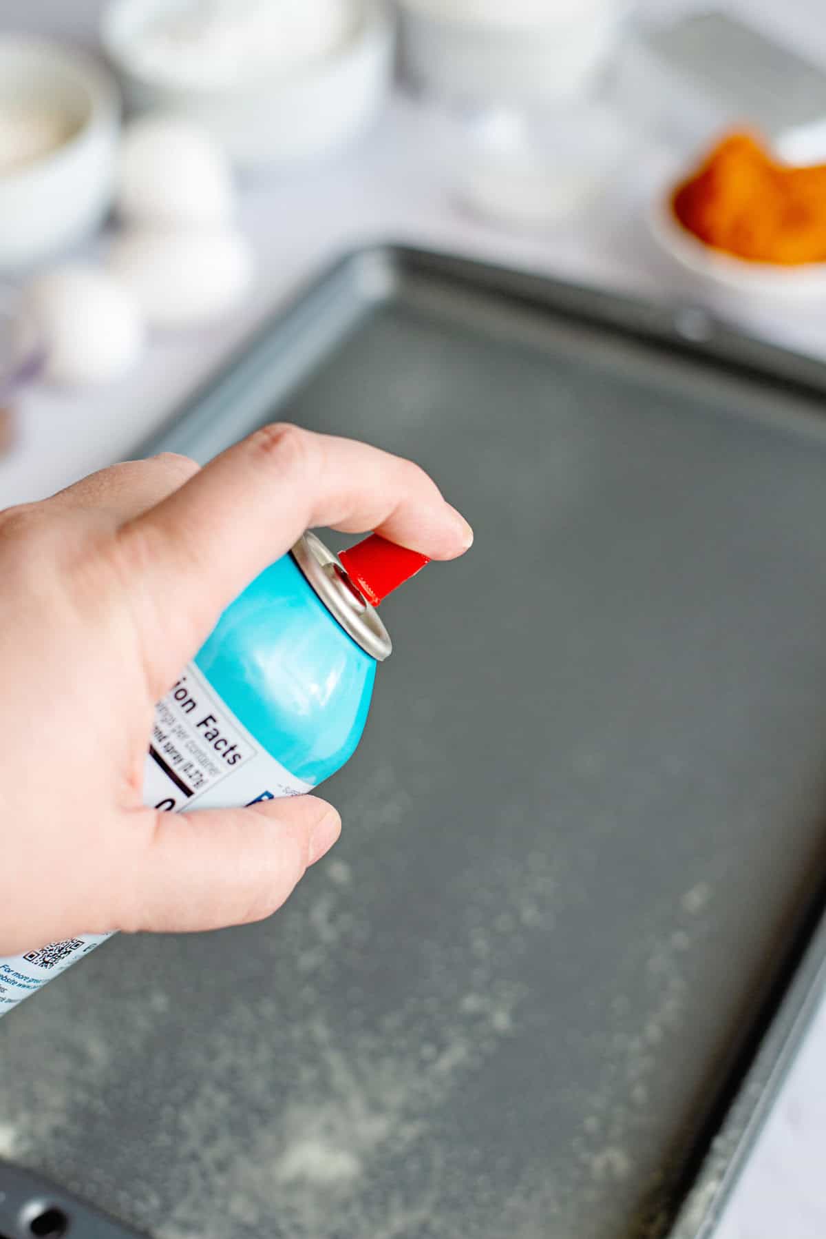 Spraying a baking sheet with cooking spray