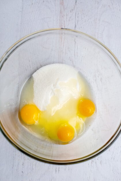 A mixing bowl with eggs and sugar