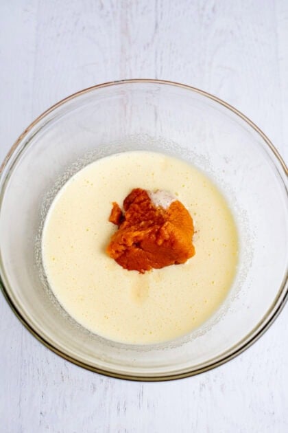 A mixing bowl with pumpkin puree and vanilla extract