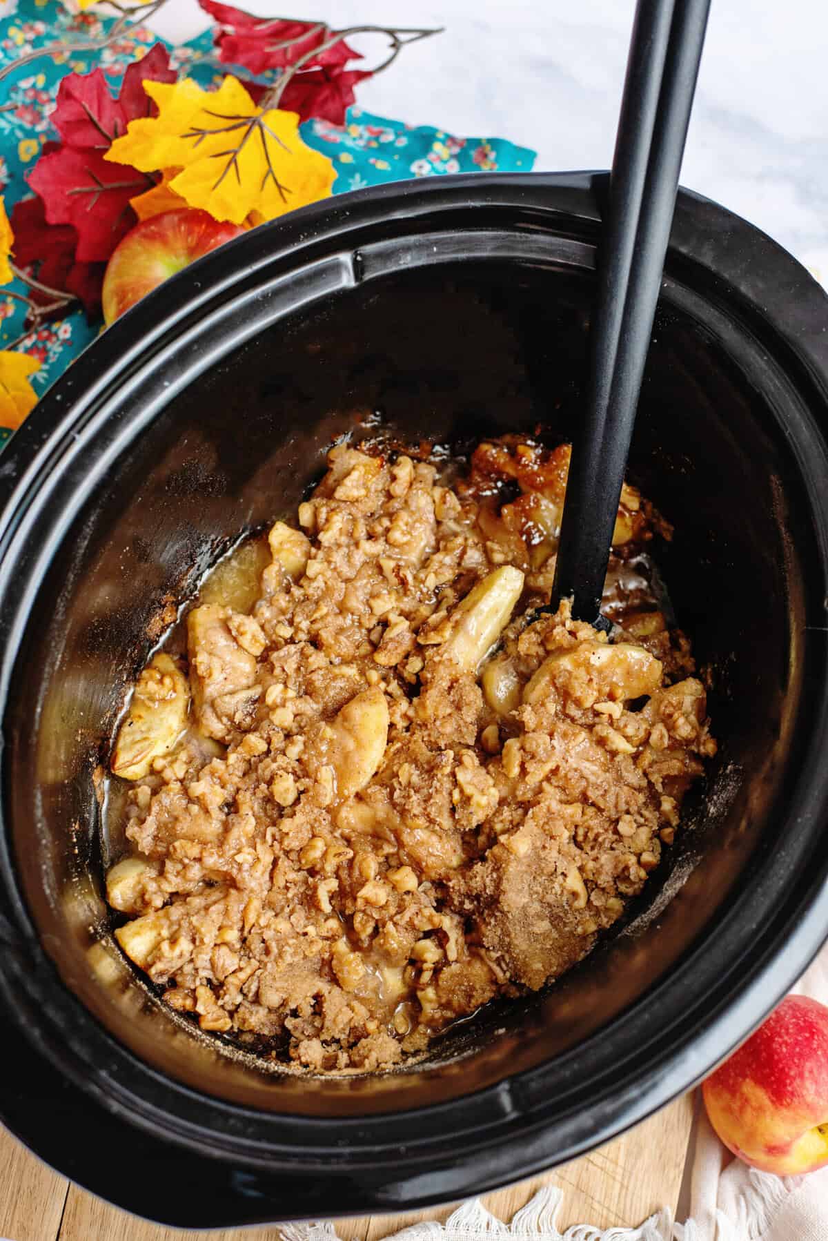 Walnuts mixed in with the rest of the slow cooker apple crisp in a crockpot