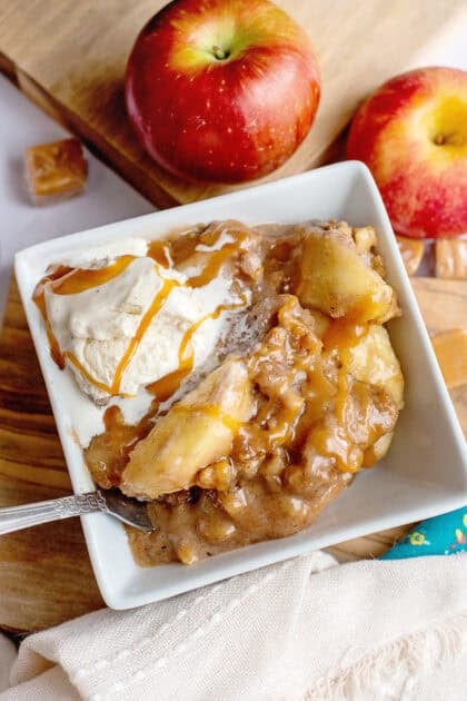 A bowl of slow cooker apple crisp with cream