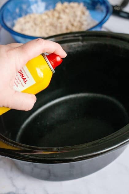 Spraying a slow cooker with non-stick cooking spray