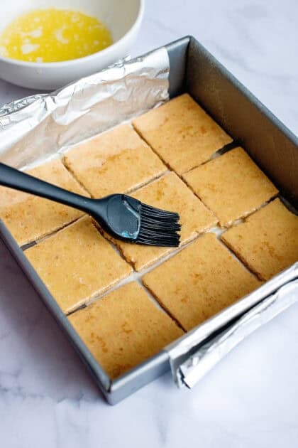 brushing the graham crackers for the s'mores brownie base with butter