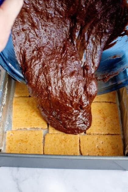Pouring brownie batter over the graham cracker base