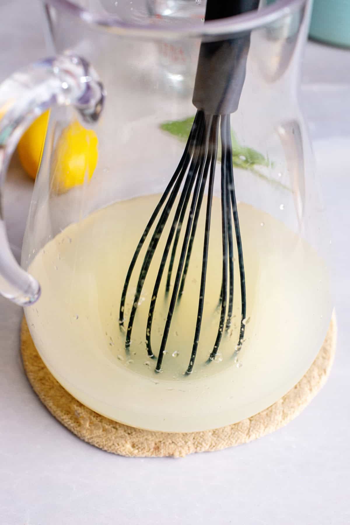 Mixing lemon juice, sugar, and water for Arnold Palmer lemonade mix