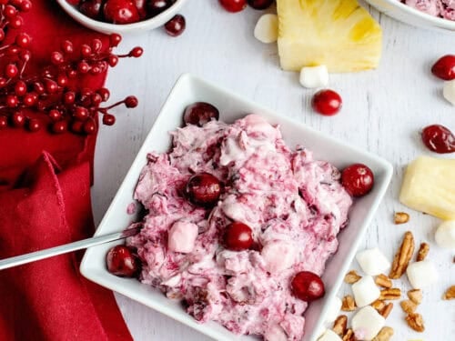 A bowl of cranberry fluff salad with fresh cranberries