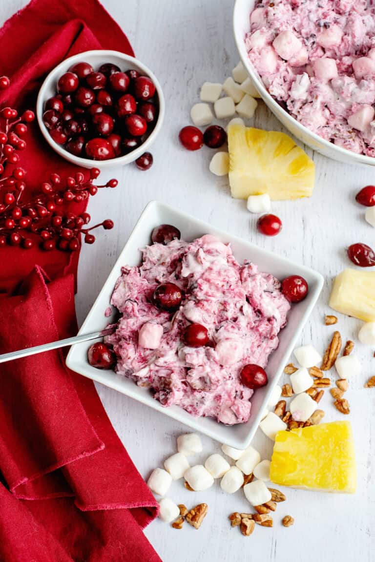 A bowl of cranberry fluff salad with fresh cranberries