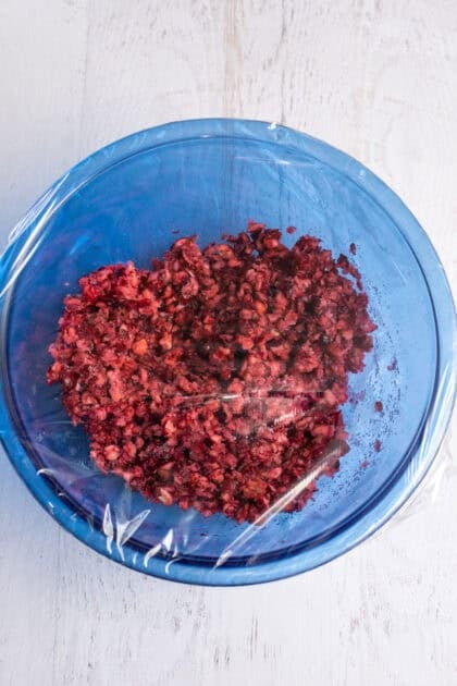 Mixed cranberry and sugar mixture in a covered bowl