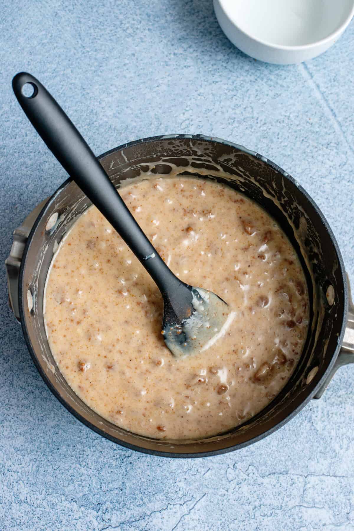Folding in the Biscoff crumble to the eggnog fudge mixture