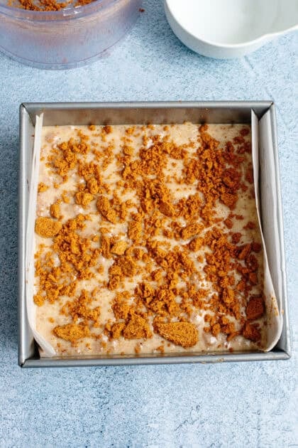 Sprinkled Biscoff cookie crumble on top of eggnog fudge mixture